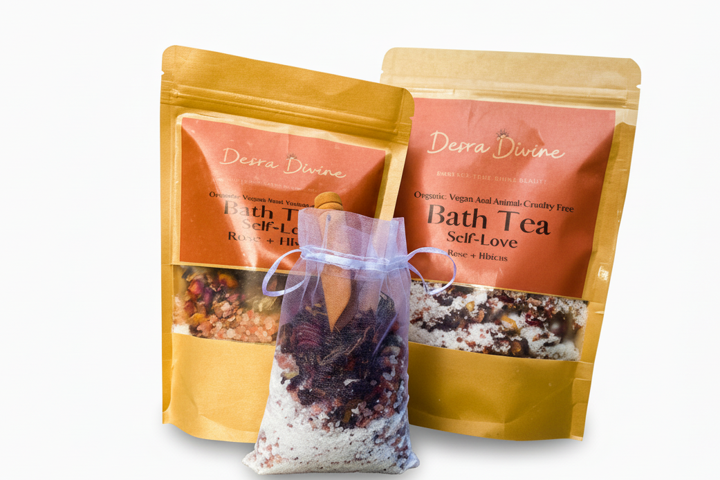 Two packages of Desra Divine Bath Tea on a white background with a smaller white bag of bath tea and a wooden spoon on a white background. This is display is meant to show size difference between Medium and Grande. 