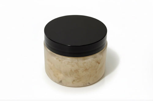 A plastic Jar with white color body scrub with  a black lid on a white background