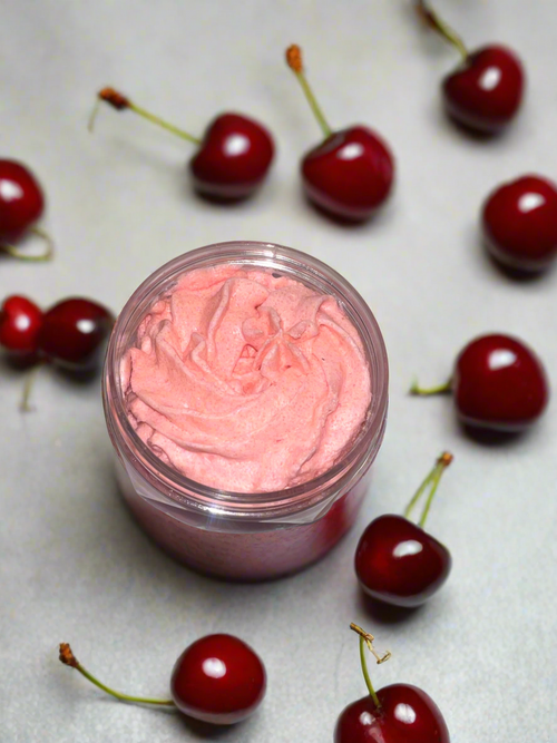Jar of pink cream with cherries around on a light surface