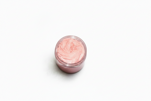 Plastic jar of pink cream cherries body scrub on a white background